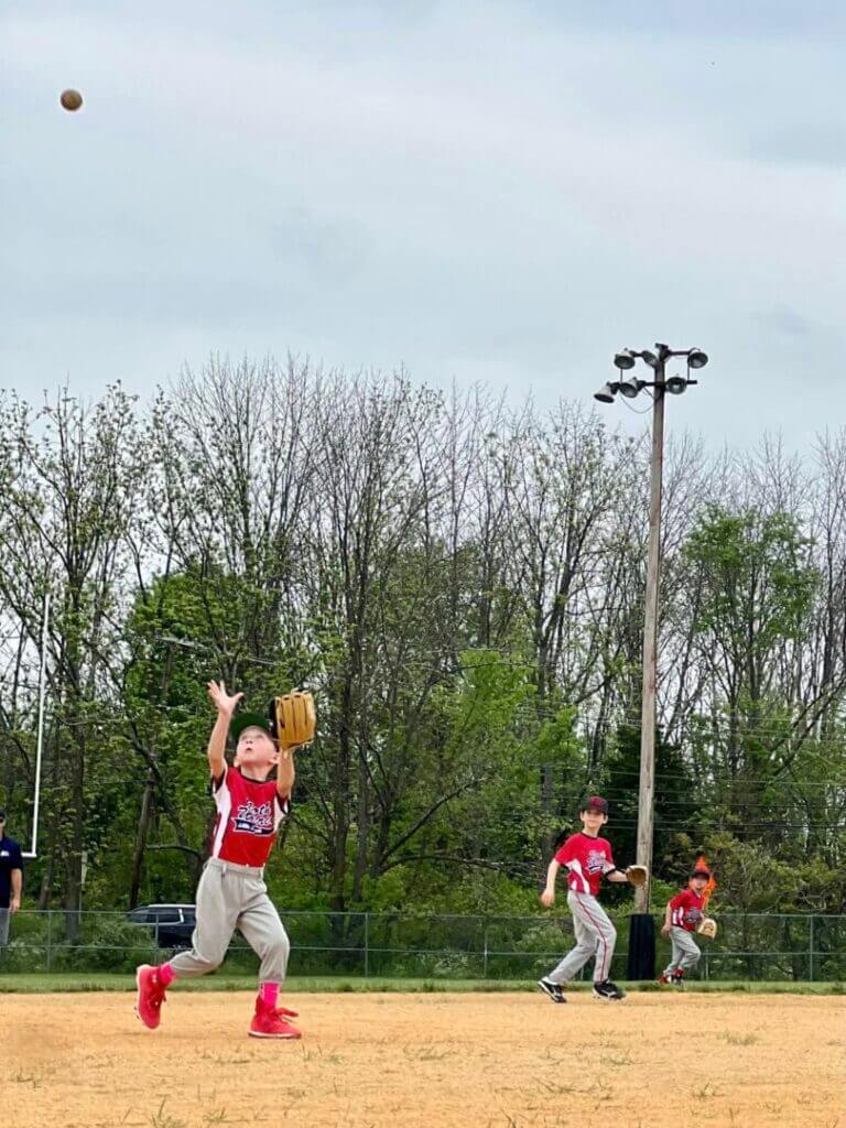 Youth baseball batter swinging at home plate