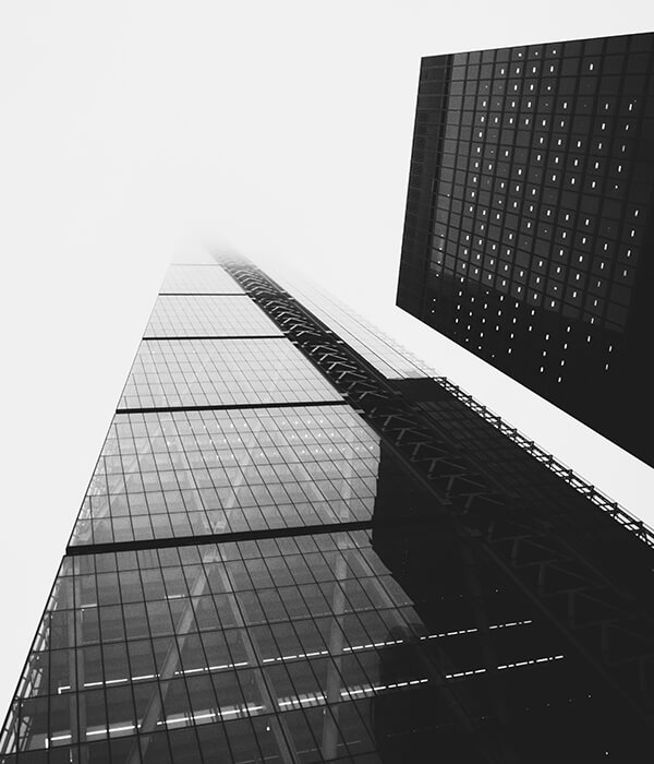 Black-and-white view up a glass skyscraper