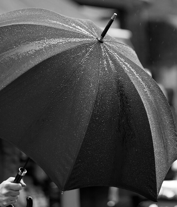 Black-and-white photo of a person under an umbrella